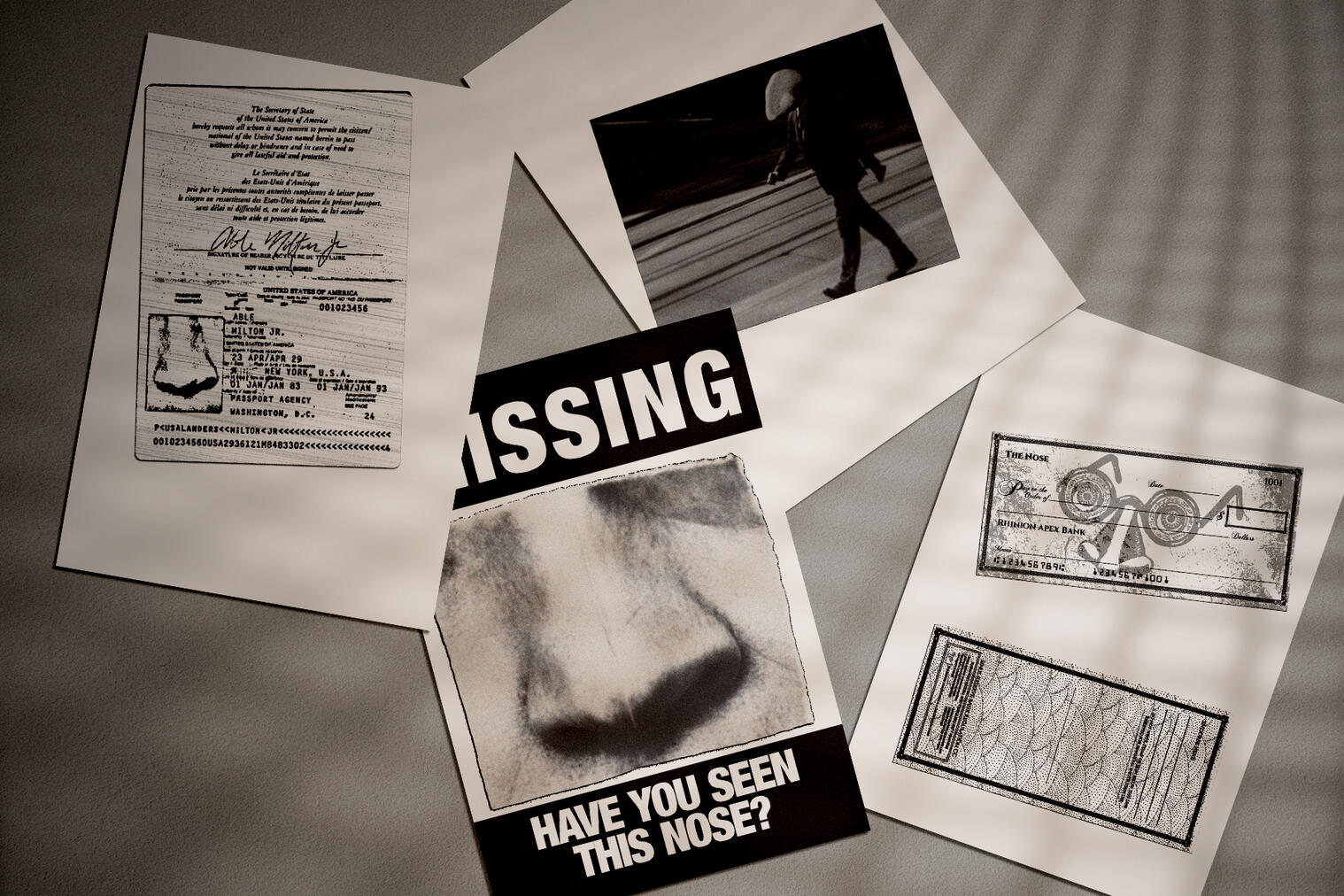 Ephemera evidence of the Nose through a passport, a missing photo, a secret spy photo, and custom cheques.